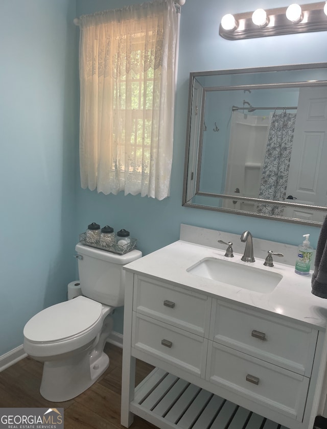 bathroom with vanity, toilet, and hardwood / wood-style floors