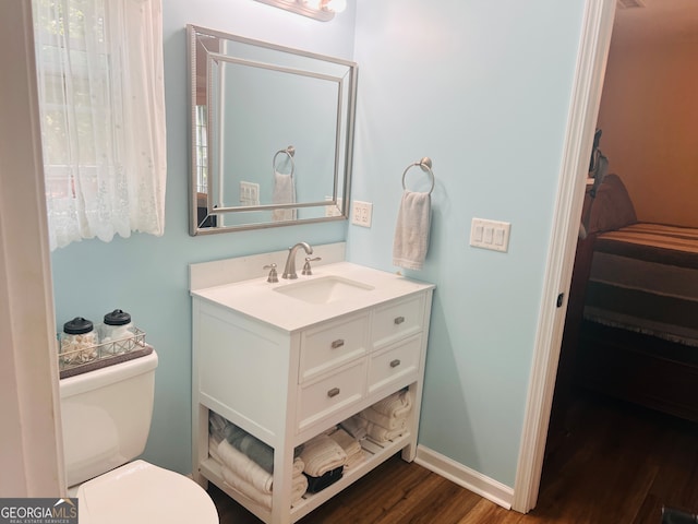 bathroom featuring vanity, toilet, and hardwood / wood-style flooring