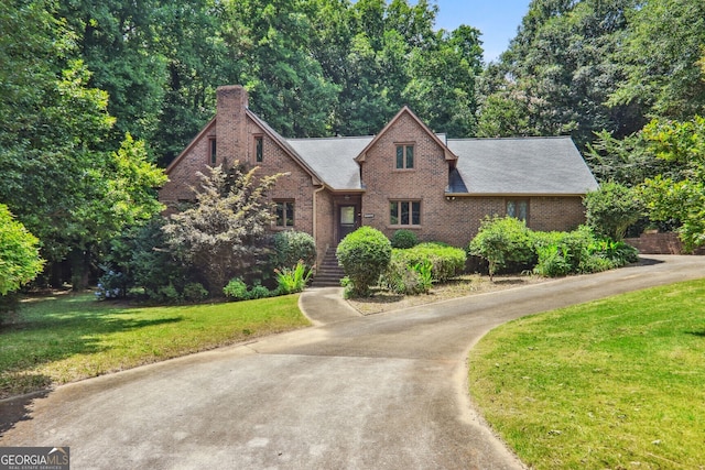 english style home featuring a front yard