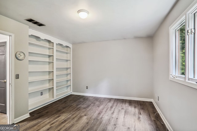 empty room with hardwood / wood-style flooring and a healthy amount of sunlight