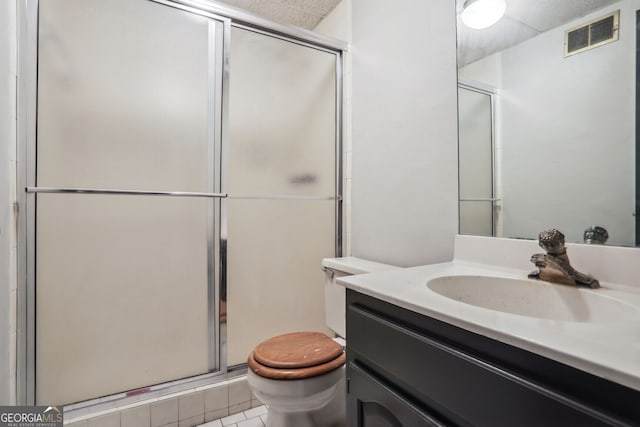 bathroom with tile patterned flooring, vanity, toilet, and an enclosed shower