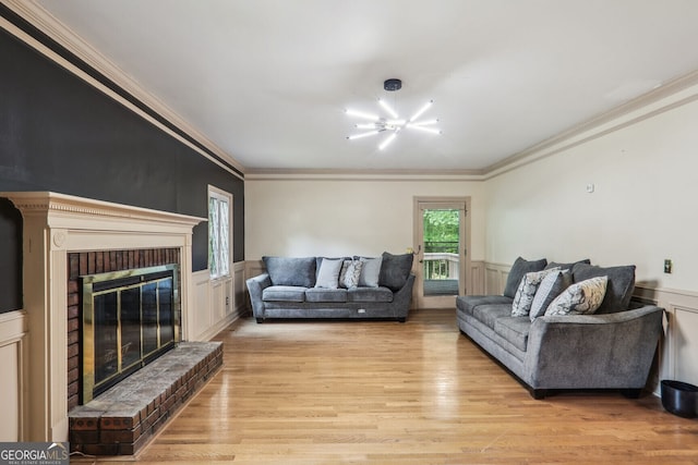 living room with a brick fireplace, light hardwood / wood-style flooring, and crown molding