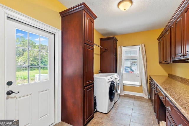 clothes washing area with cabinets, light tile patterned flooring, a healthy amount of sunlight, and washing machine and clothes dryer