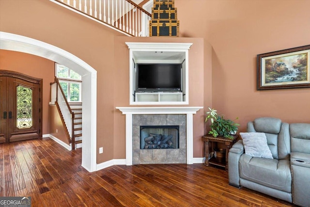 unfurnished living room featuring dark hardwood / wood-style flooring, french doors, and a fireplace