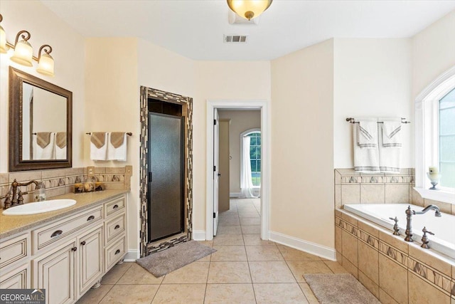 bathroom featuring tile patterned floors, vanity, and shower with separate bathtub