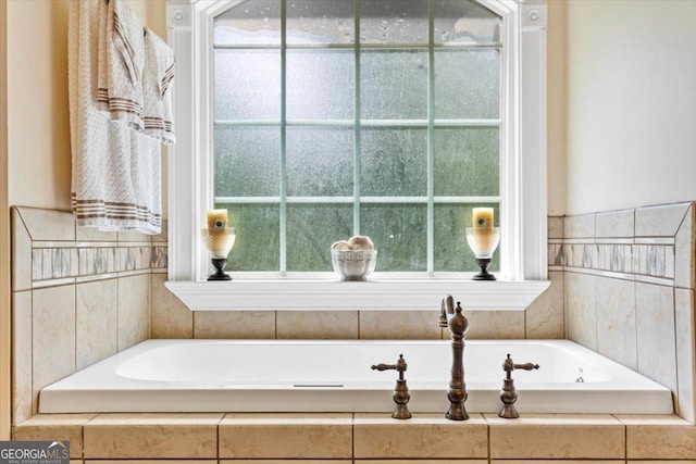 bathroom featuring plenty of natural light and a relaxing tiled tub