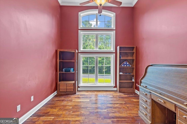 unfurnished office with ceiling fan, dark hardwood / wood-style floors, a high ceiling, and ornamental molding