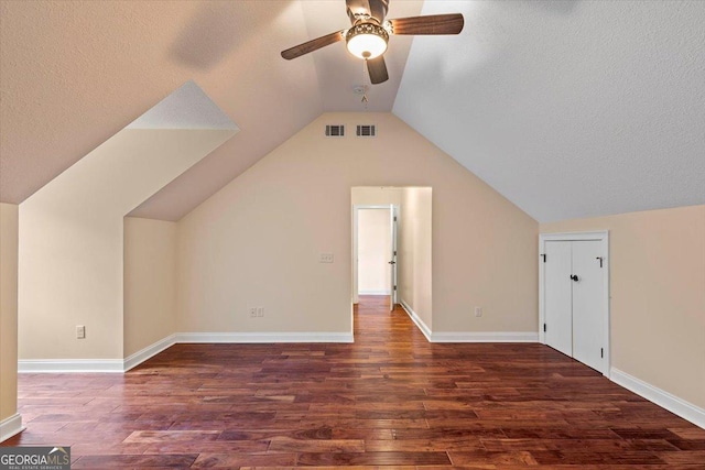 bonus room featuring dark wood-type flooring, a textured ceiling, and lofted ceiling