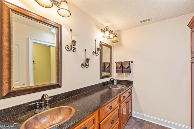 bathroom with a textured ceiling and vanity