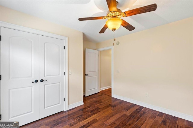 unfurnished bedroom with ceiling fan, dark hardwood / wood-style floors, and a closet