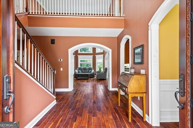 foyer featuring dark wood-type flooring and a towering ceiling