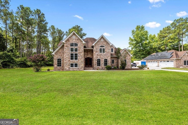 view of front of house with a garage and a front lawn