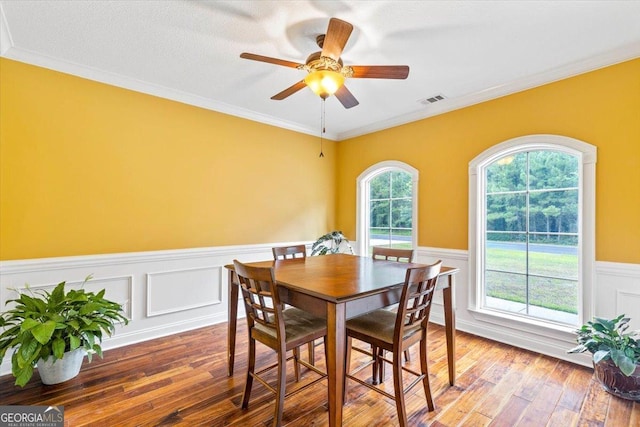 dining space featuring ceiling fan, hardwood / wood-style floors, ornamental molding, and a textured ceiling