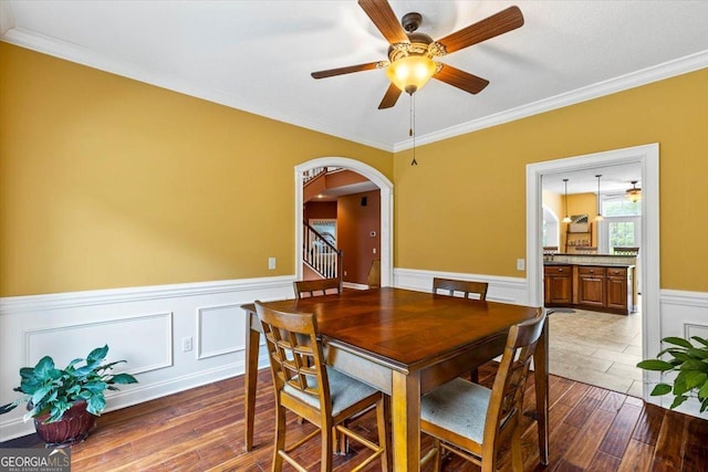 dining area with ceiling fan and crown molding