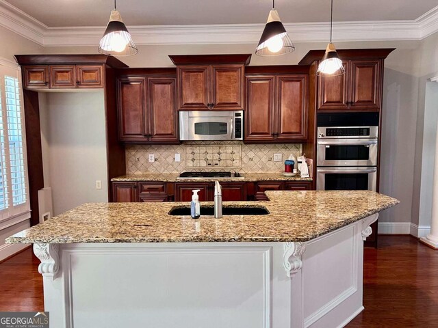 kitchen with dark hardwood / wood-style floors, tasteful backsplash, appliances with stainless steel finishes, sink, and pendant lighting