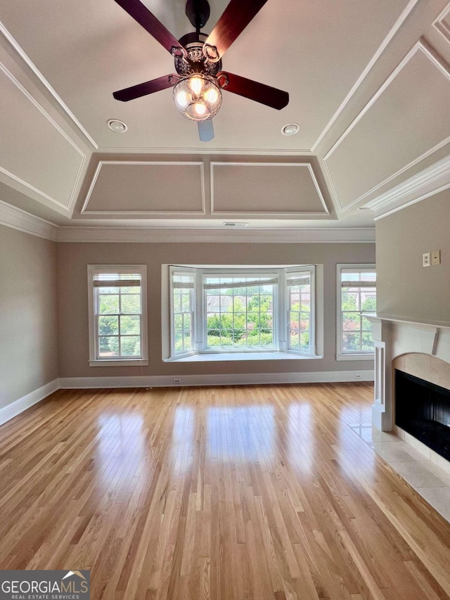 unfurnished living room with ceiling fan, ornamental molding, light hardwood / wood-style floors, and a fireplace