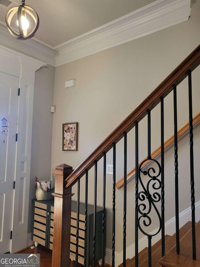 staircase featuring ornamental molding and hardwood / wood-style flooring