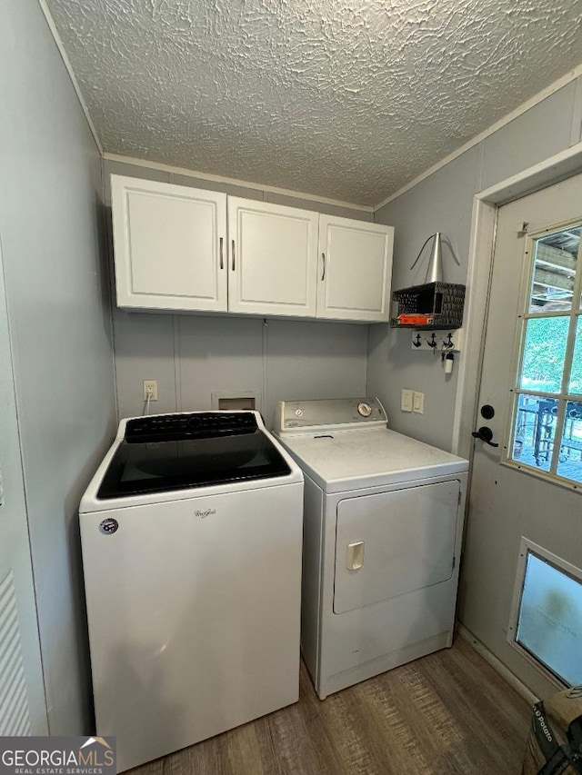 washroom featuring cabinets, washing machine and dryer, light wood-type flooring, and a textured ceiling