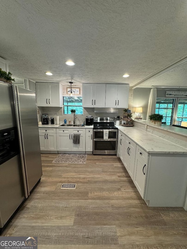 kitchen with white cabinets, stainless steel appliances, light hardwood / wood-style flooring, and sink