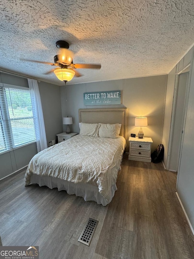 bedroom featuring ceiling fan, a textured ceiling, and hardwood / wood-style flooring