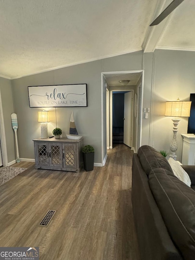 living room featuring ornamental molding, hardwood / wood-style flooring, and vaulted ceiling