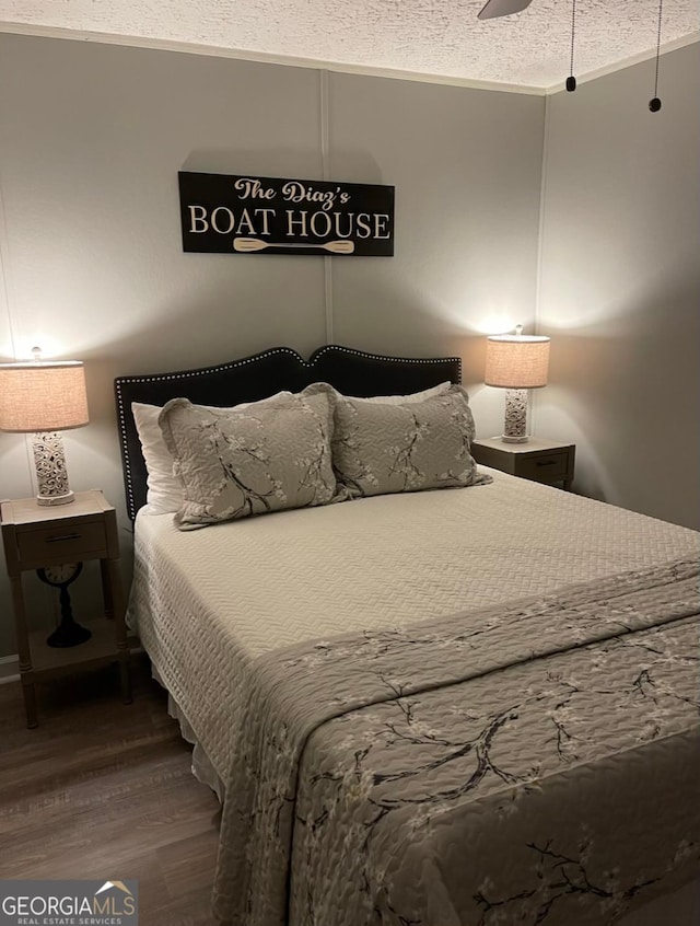 bedroom featuring a textured ceiling, ceiling fan, and hardwood / wood-style floors