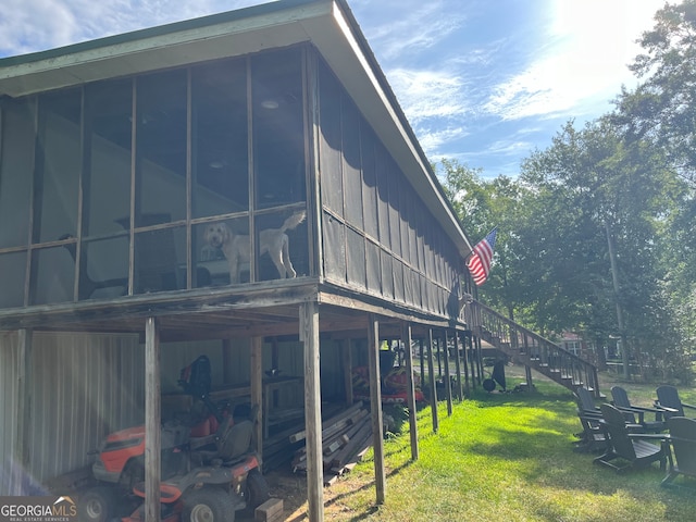 view of home's exterior featuring a sunroom and a lawn