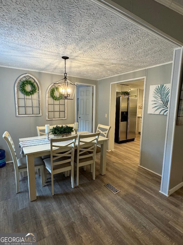 dining area featuring a chandelier, a textured ceiling, and hardwood / wood-style floors