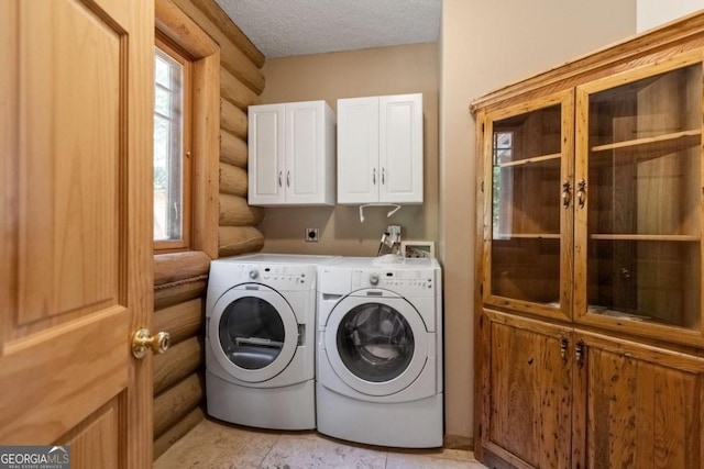 laundry area featuring separate washer and dryer, a wealth of natural light, cabinets, and rustic walls