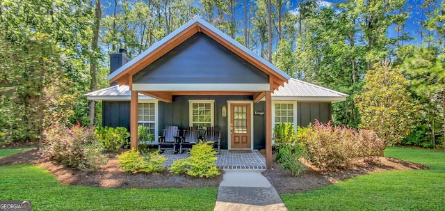 bungalow-style home featuring covered porch and a front yard