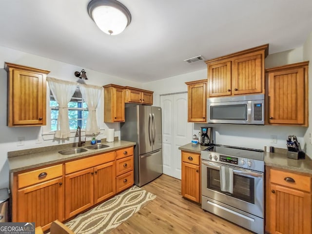 kitchen with light hardwood / wood-style floors, sink, and stainless steel appliances