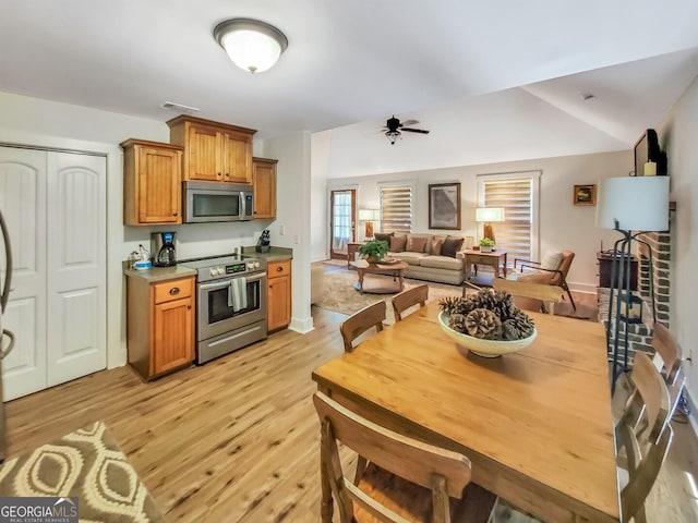 kitchen with stainless steel appliances, ceiling fan, and light hardwood / wood-style floors