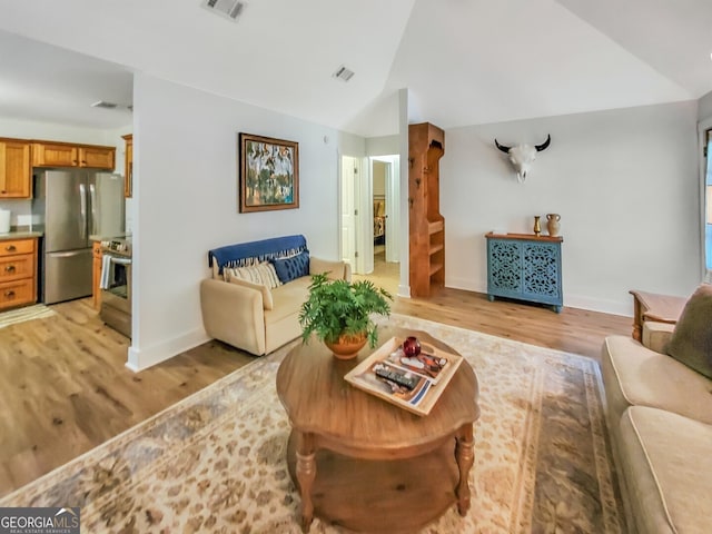 living room featuring vaulted ceiling and light wood-type flooring