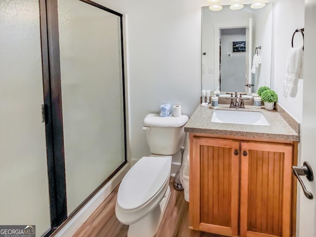 bathroom with wood-type flooring, vanity, and toilet