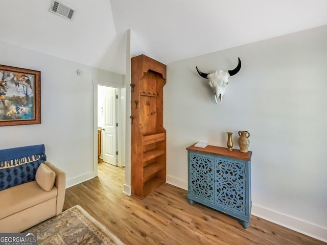 sitting room with hardwood / wood-style floors and lofted ceiling