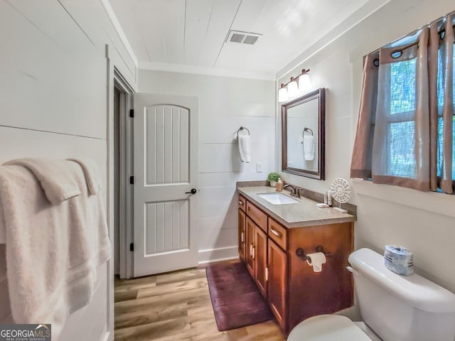 bathroom featuring ornamental molding, hardwood / wood-style flooring, toilet, and vanity