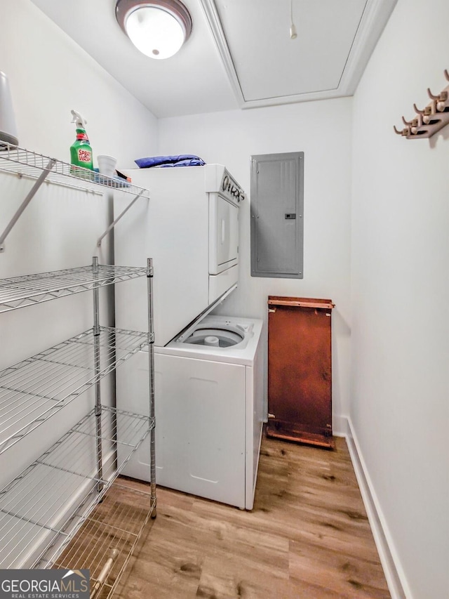 clothes washing area featuring light hardwood / wood-style floors and stacked washer and clothes dryer