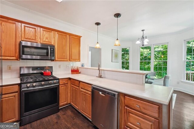 kitchen featuring decorative backsplash, dark hardwood / wood-style floors, appliances with stainless steel finishes, kitchen peninsula, and decorative light fixtures