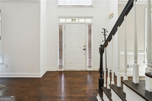 entryway with wood-type flooring and a high ceiling