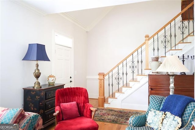 living room with crown molding, lofted ceiling, and wood-type flooring