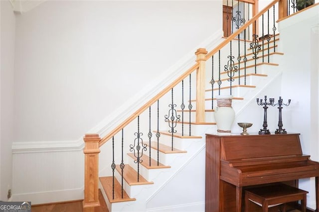 stairway with hardwood / wood-style floors and ornamental molding