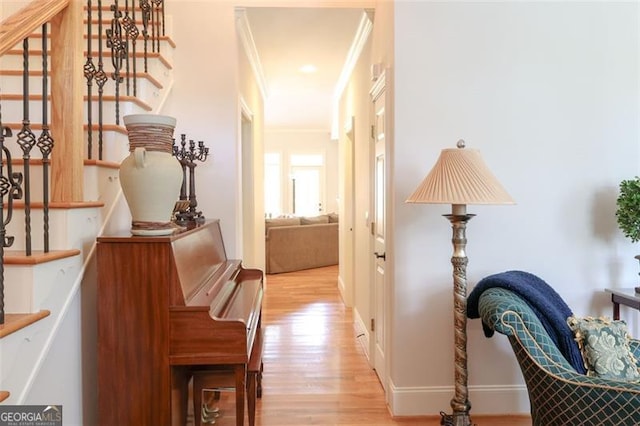 hall featuring light wood-type flooring and crown molding