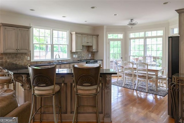 kitchen featuring ornamental molding, hardwood / wood-style floors, backsplash, and cream cabinetry