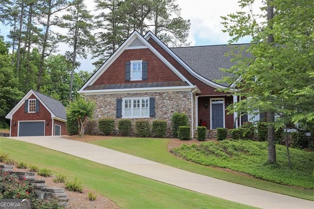 craftsman inspired home featuring an outdoor structure, a garage, and a front lawn