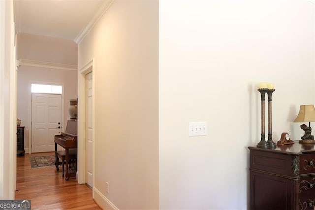 hall featuring ornamental molding and light hardwood / wood-style floors