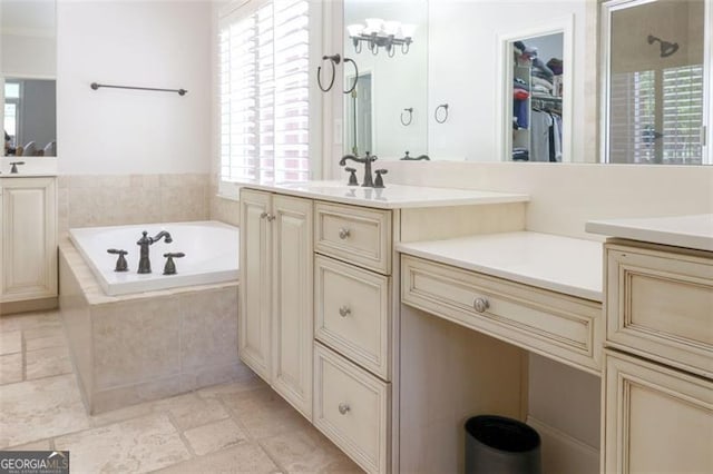 bathroom with tile floors, tiled tub, and vanity