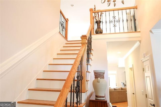 stairway featuring hardwood / wood-style flooring and crown molding