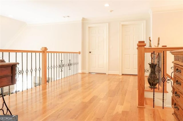 hallway featuring light hardwood / wood-style flooring and crown molding