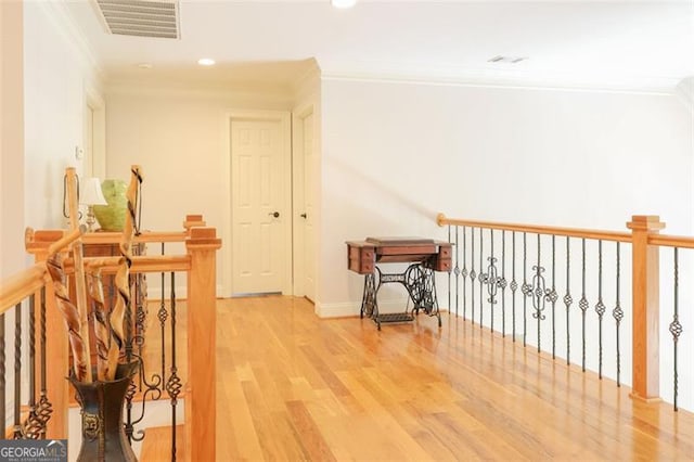 hall with ornamental molding and light wood-type flooring