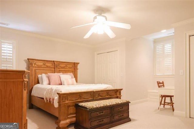 bedroom featuring ornamental molding, a closet, ceiling fan, and light colored carpet